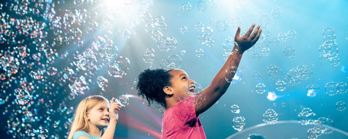 Children reaching for bubbles during a family entertainment show at Dollywood