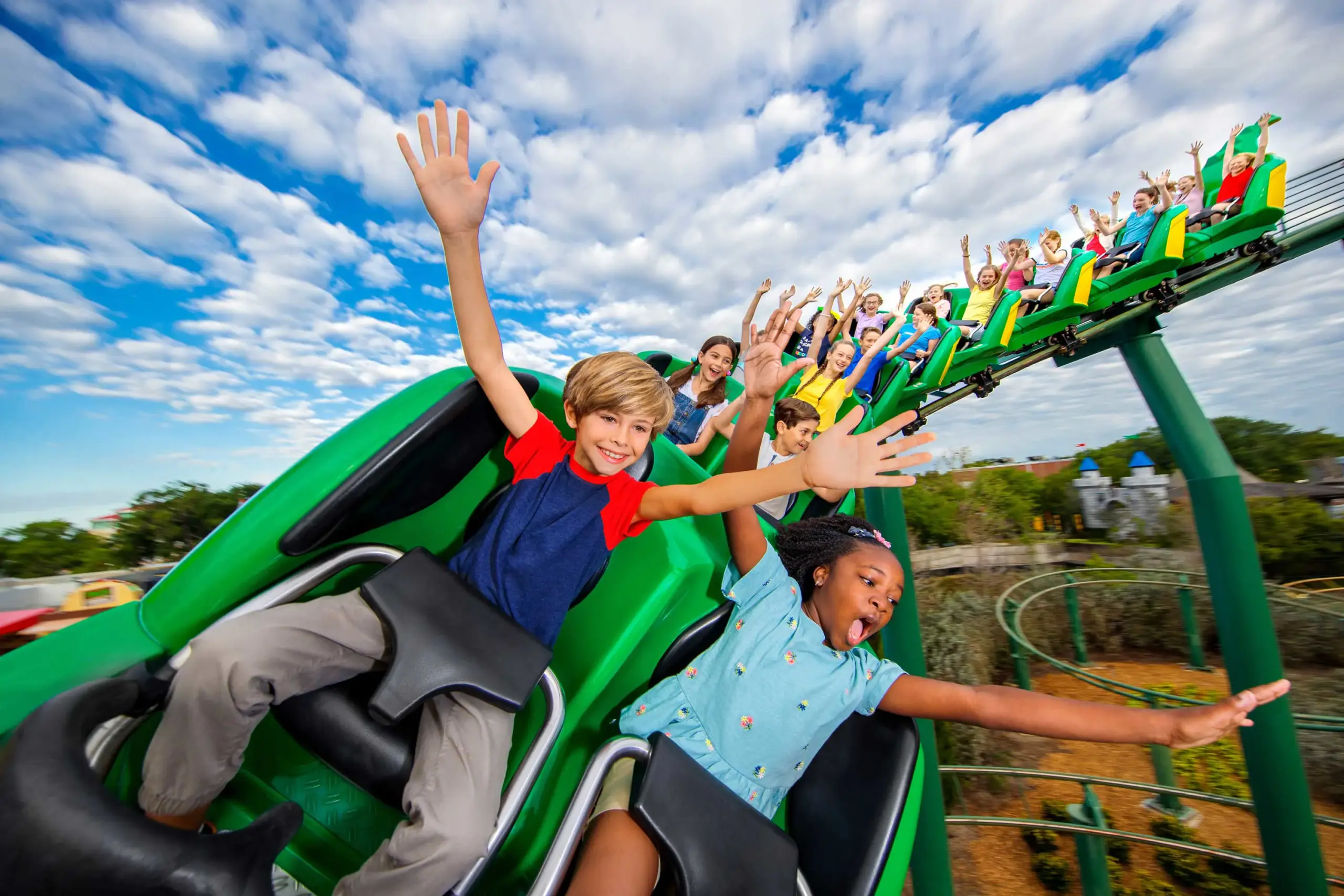 Children riding the green Dragon roller coaster at LEGOLAND Florida Resort