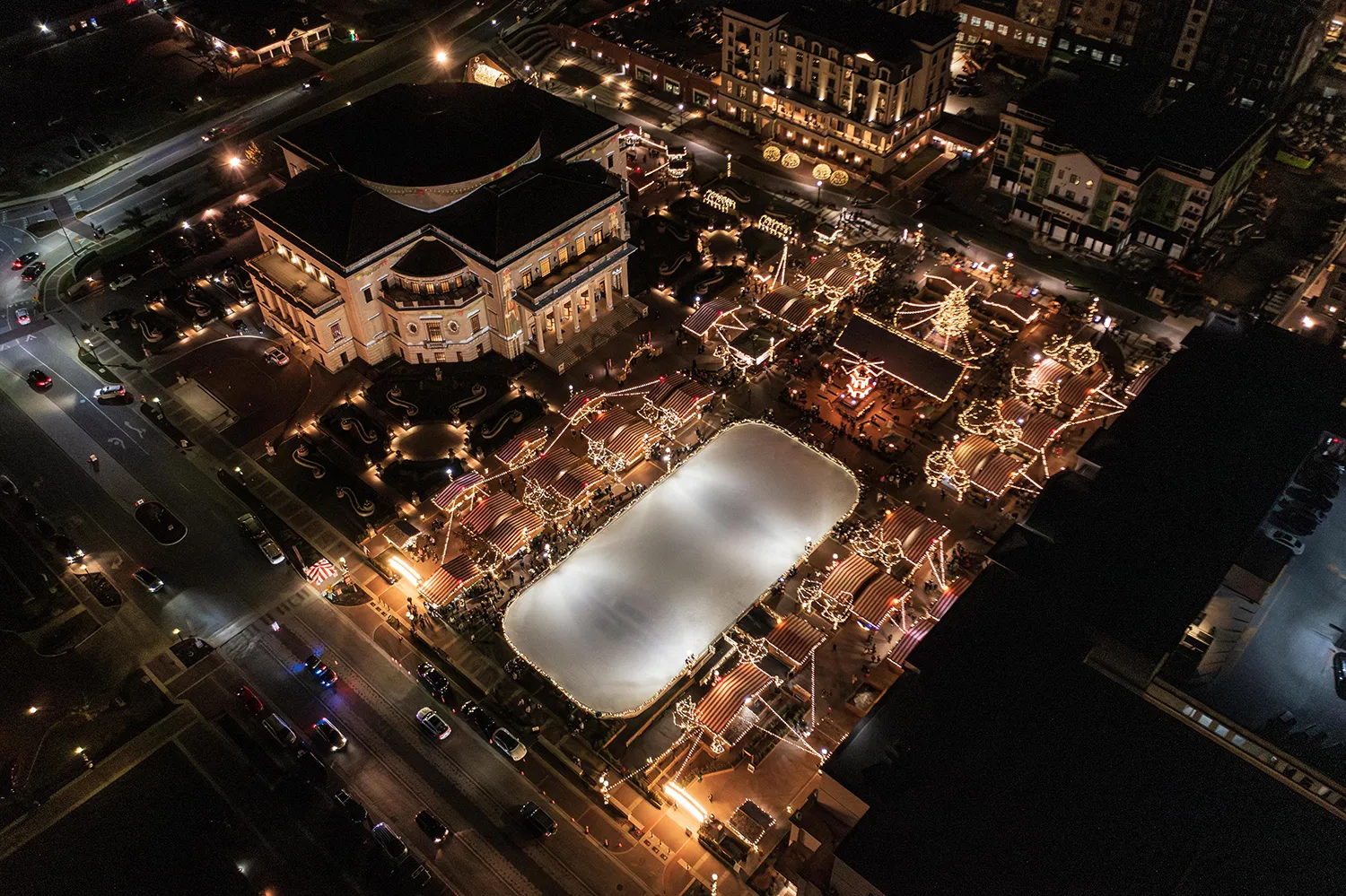 Aerial nighttime view of Carmel Christkindlmarkt with the illuminated ice rink, holiday lights and market booths