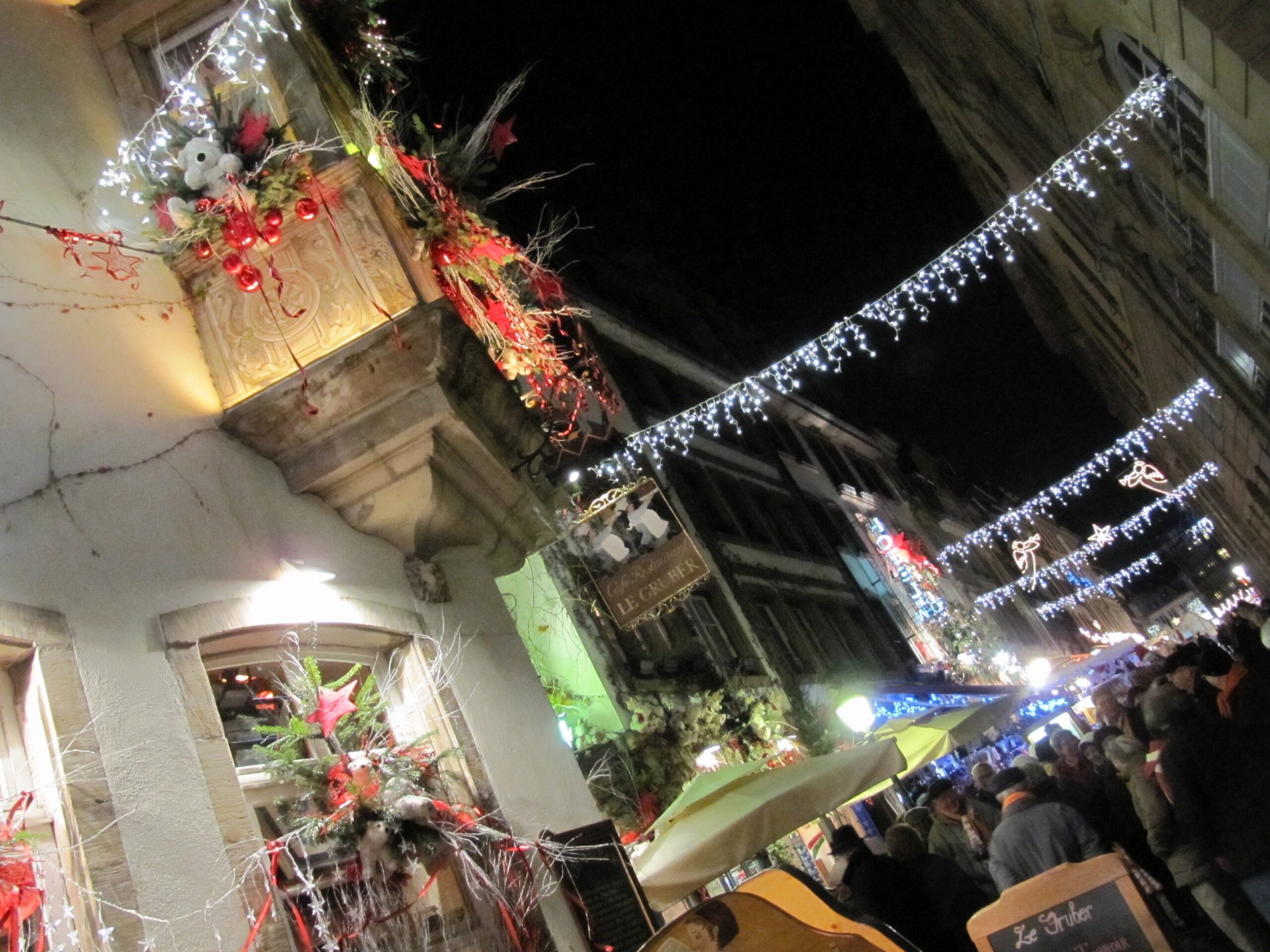 Christmas lights and crowds along a Strasbourg street during the Christmas market at night
