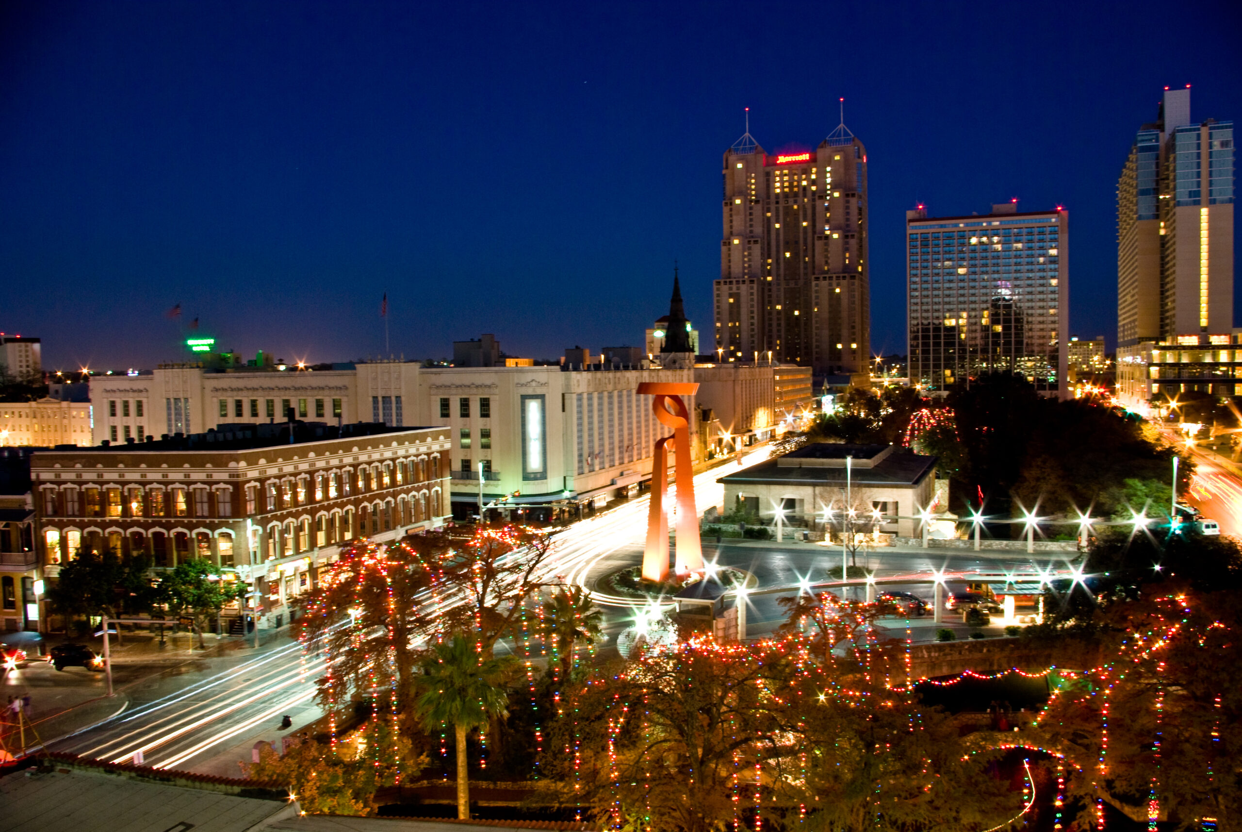 Downtown San Antonio skyline and trees covered in Christmas lights at night