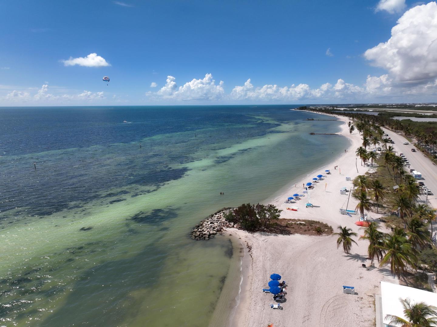 Aerial view of Smathers Beach in Key West with white sand, palm trees and turquoise water