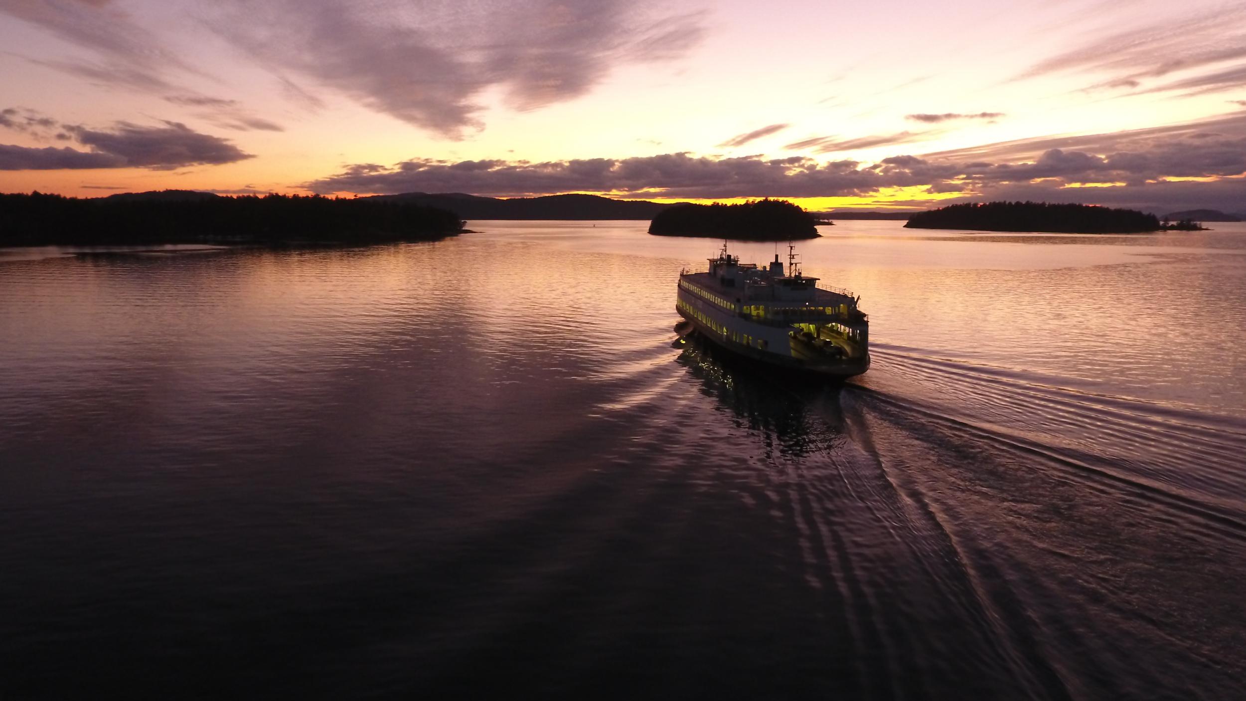 A Washington State ferry traveling through Wasp Passage at sunset in the San Juan Islands