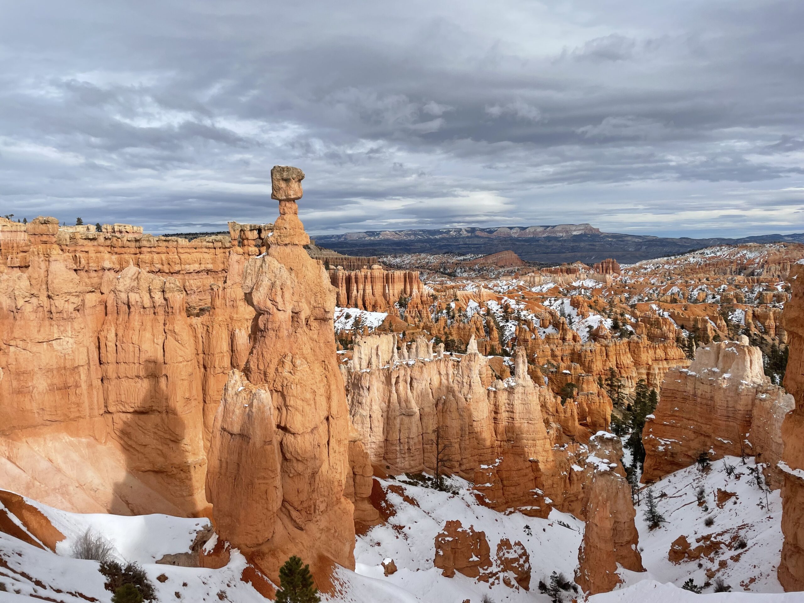 Snow-covered hoodoos and red-rock formations in Bryce Canyon National Park during winter.