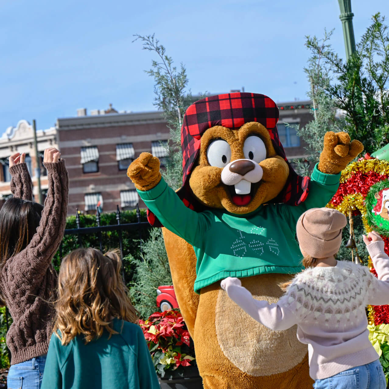 Children celebrating with Earl the Squirrel beside Christmas decorations at Universal Studios Florida