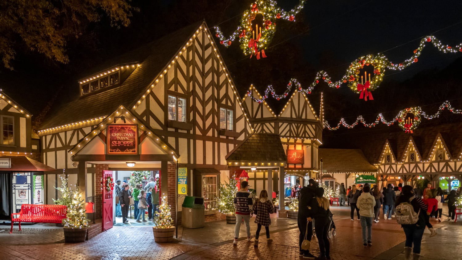 Busch Gardens Williamsburg Christmas Town illuminated with garlands, wreaths and holiday lights at night